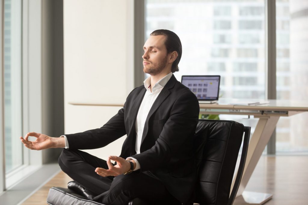 successful businessman meditating at workplace